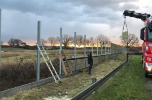 Bygger støjværn ved solnedgang