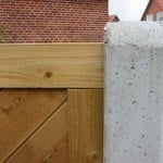 Træhegn og murstenvæg ved siden af hinanden