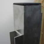 Moderne betonpostkasse tæt på trævæg